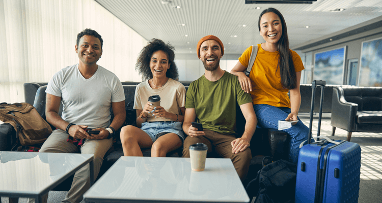 four young professionals wait at an airport