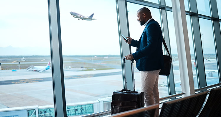 a business man walks outside at an airport